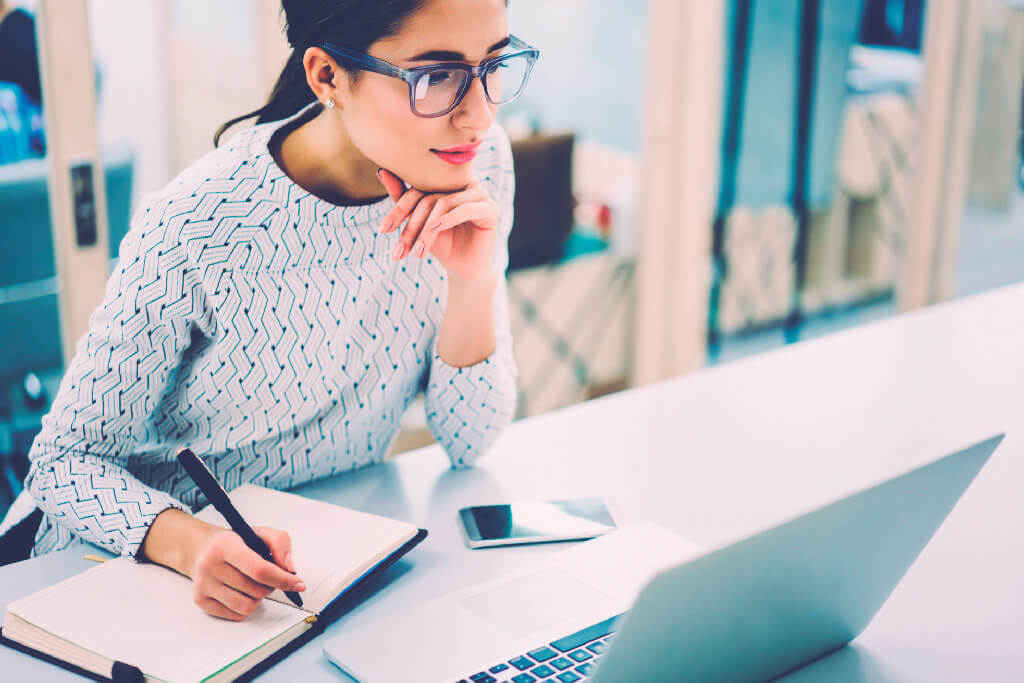 Mujer joven estudiando en un laptop