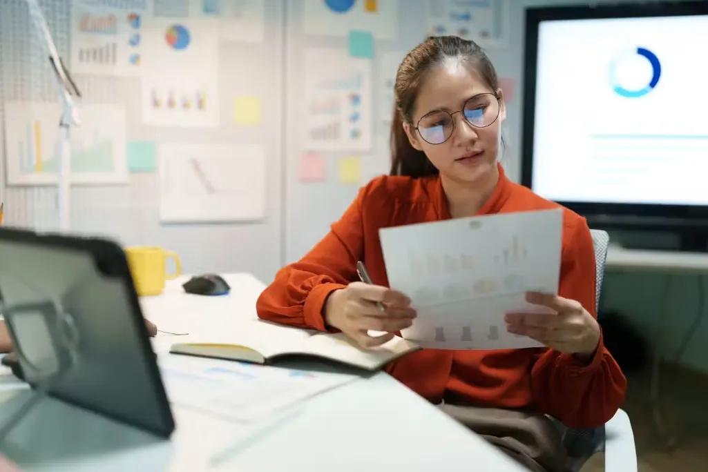 Estudiante frente de computador con papel en mano haciendo referencia a elección de carrera de continuidad de estudios para técnicos